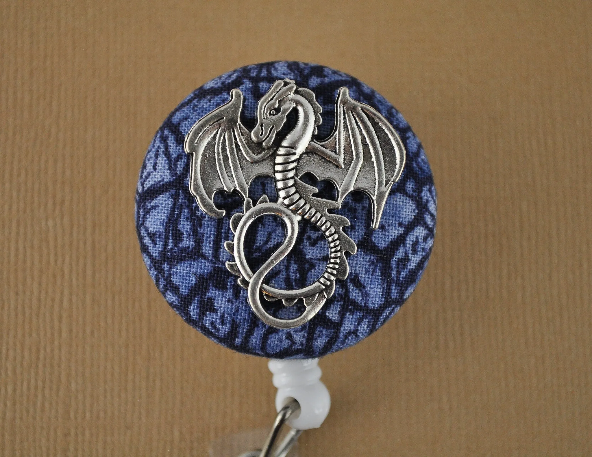 Silver dragon on blue scales badge reel