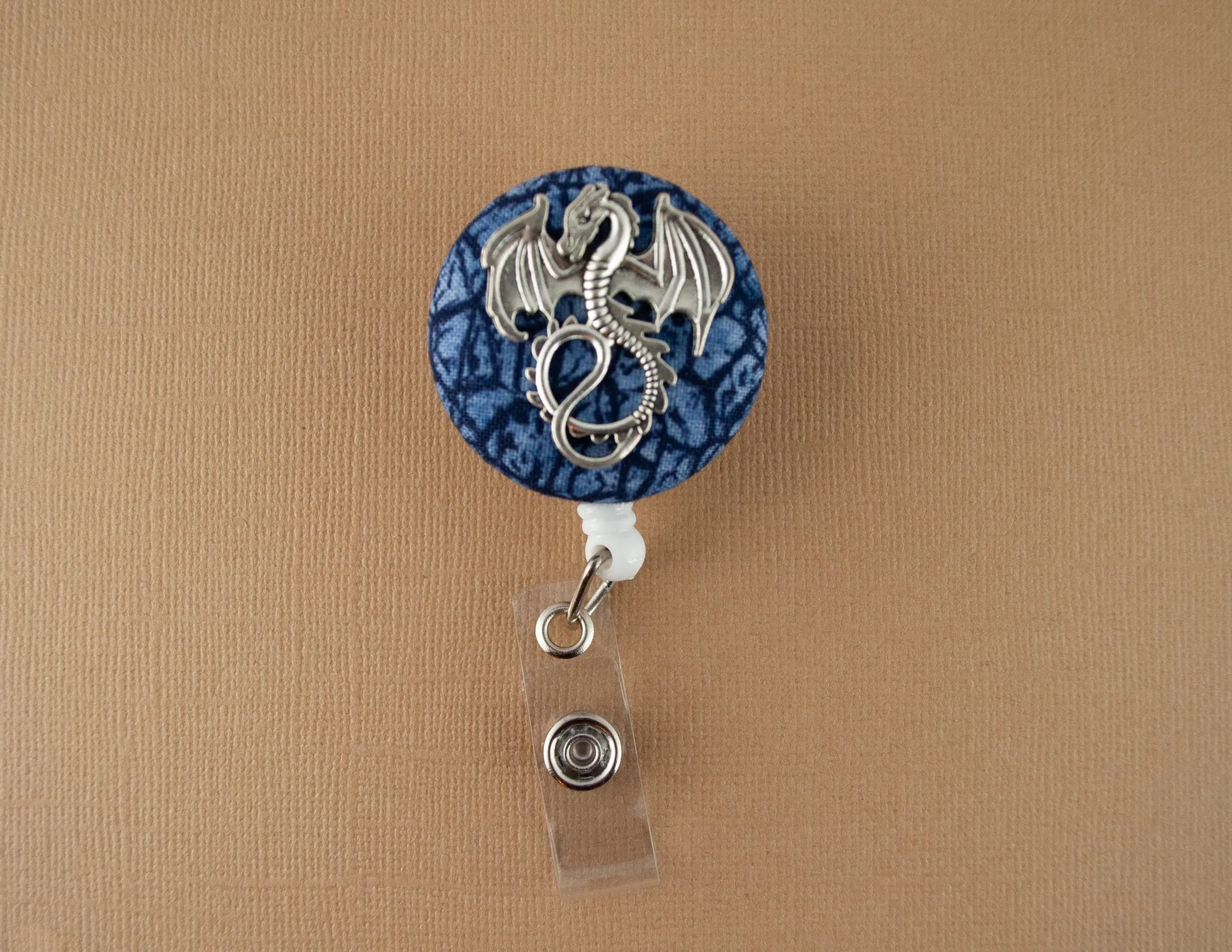 Silver dragon on blue scales badge reel