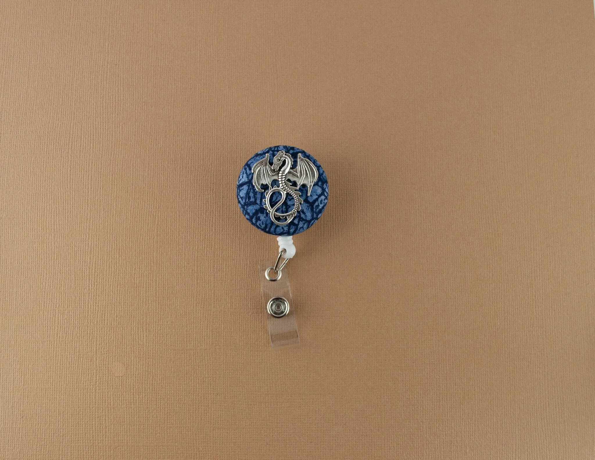 Silver dragon on blue scales badge reel